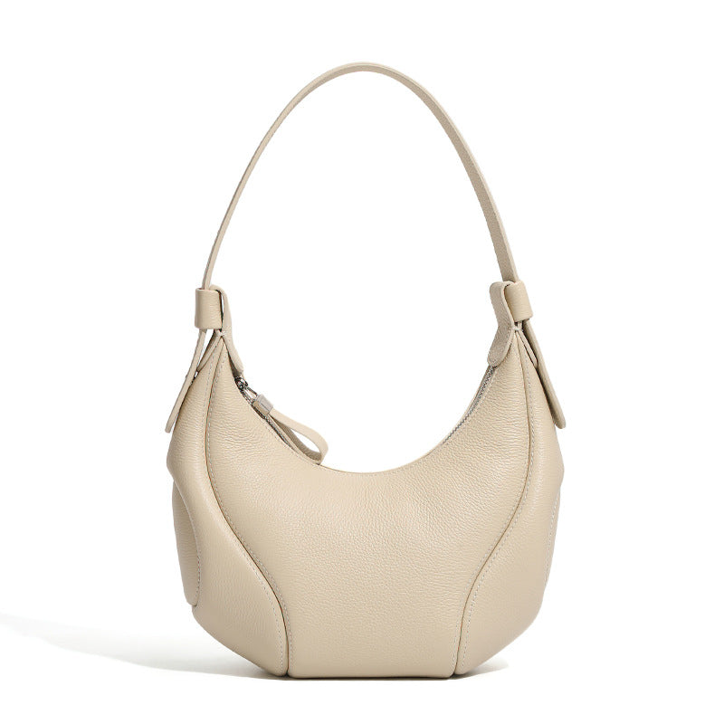Sovereign textured leather baseball hobo bag in a premium, minimalist milkshake white cream leather finish on a off-white background