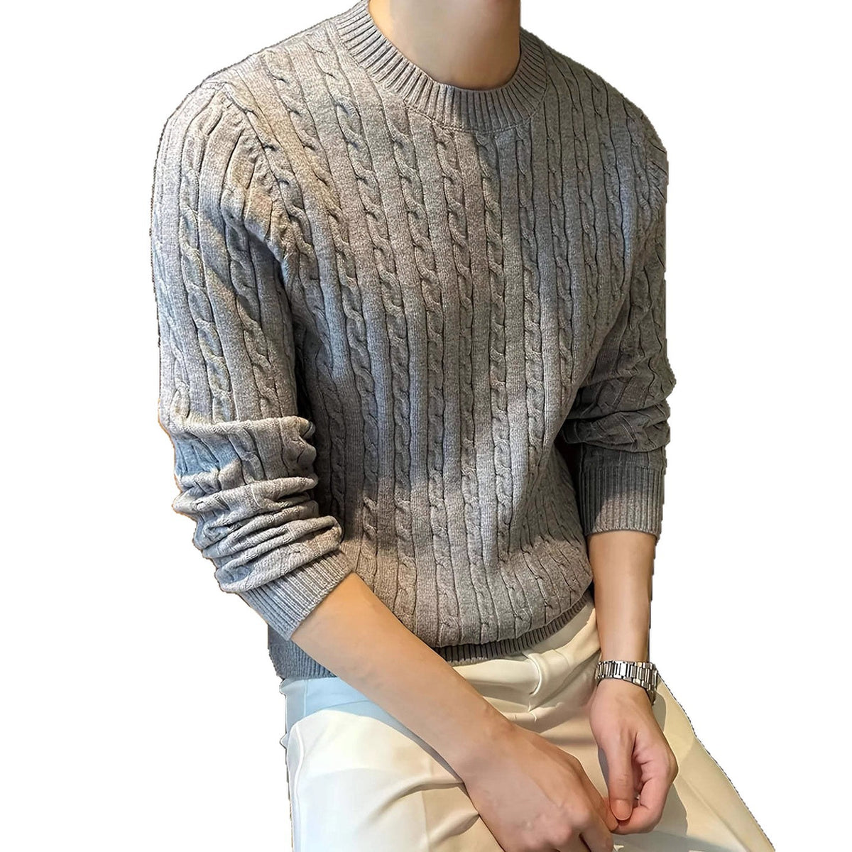 A man wearing a light gray cable-knit crewneck sweater and off-white pants, shown from the neck down against a plain white background.