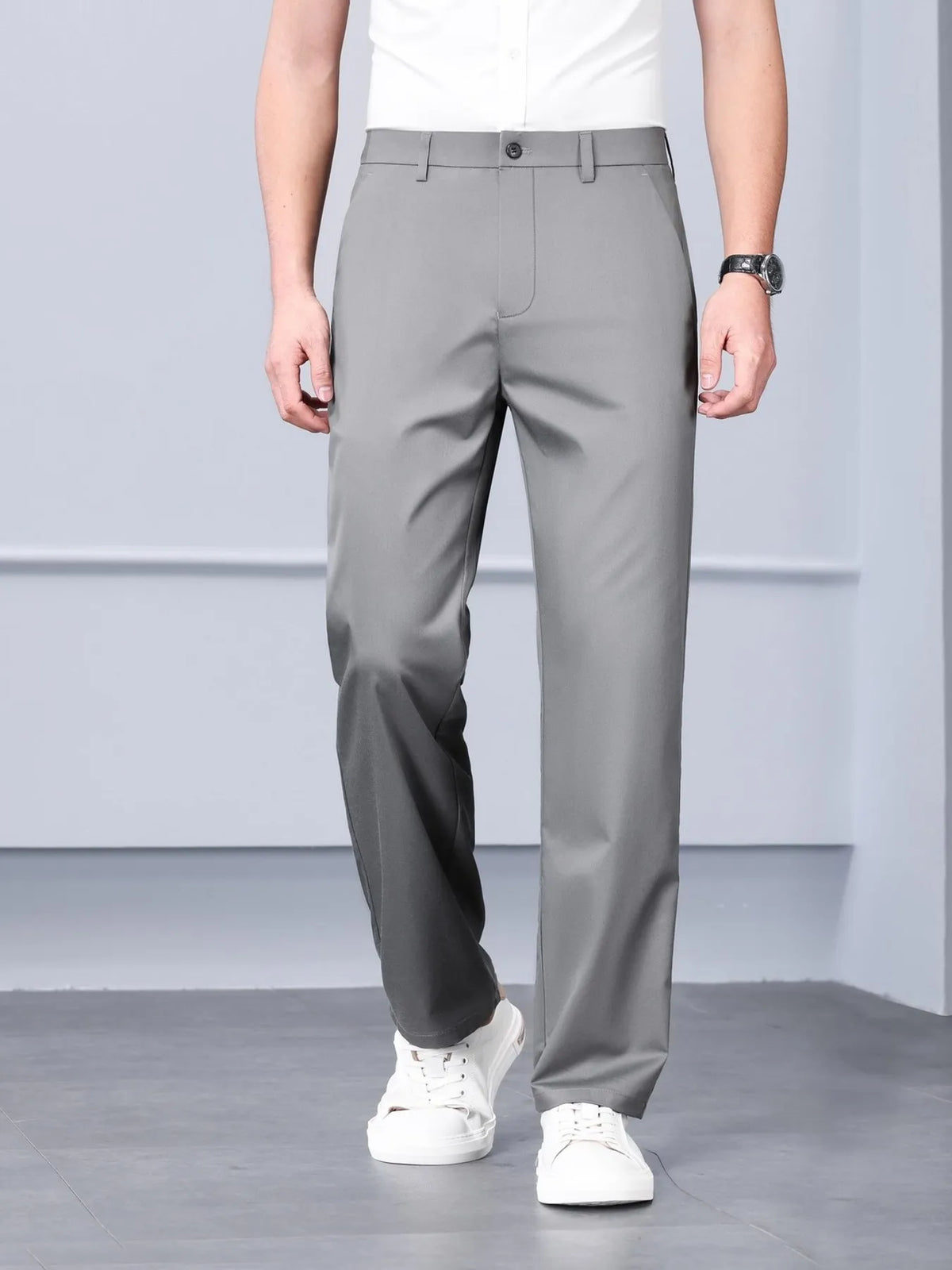 Model wearing light grey tailored silk-touch straight-leg dress pants with white sneakers 