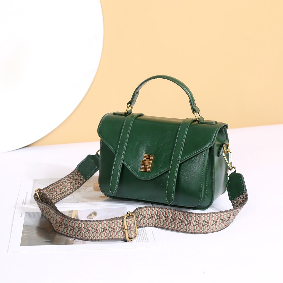 Green Luxury woven leather horizontal shoulder bag with dual shoulder straps on a an offwhite background